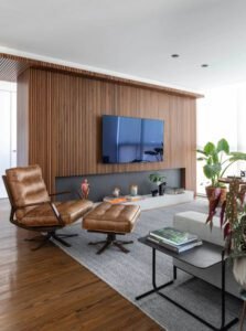 Sala de estar moderna de meados do século com lareira e parede vertical de ripas de madeira de nogueira para TV